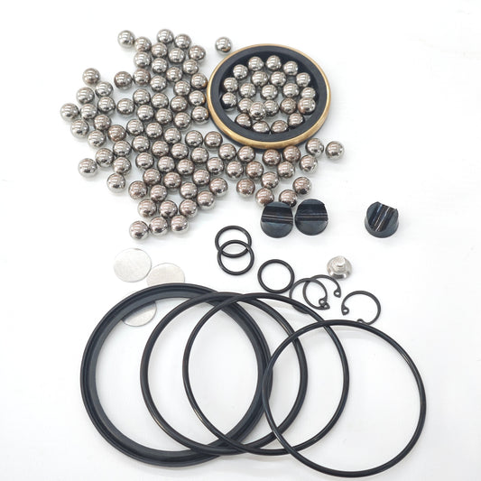 Swivel joint repair-kit seals, balls and retaining hardware arranged on a white surface.