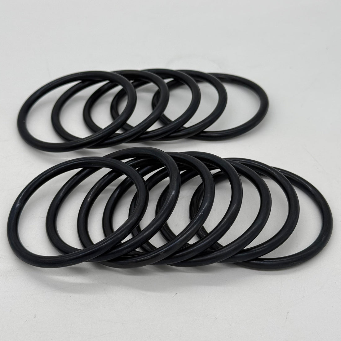 Black AS568 O-rings arranged on a white background