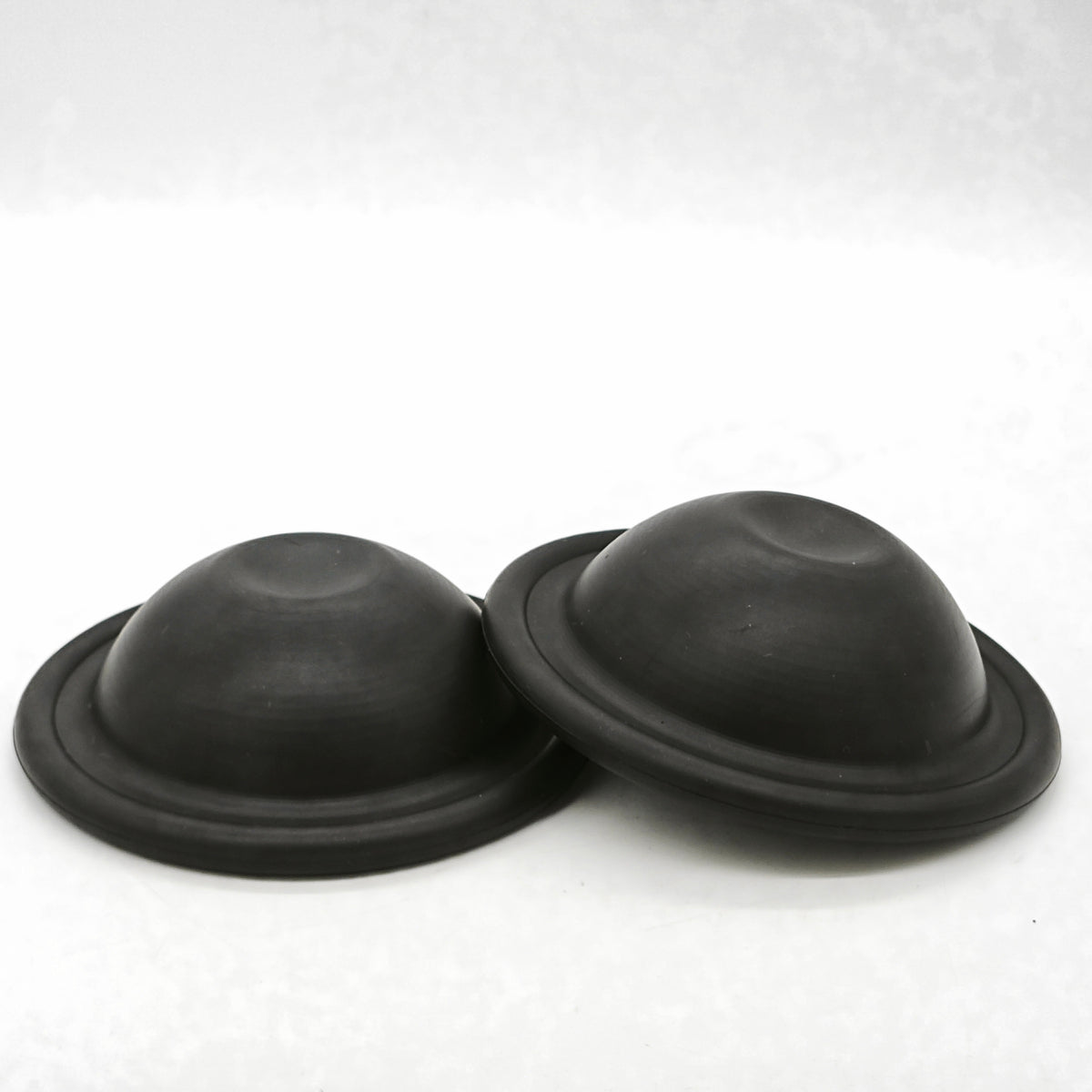 Two black 550190 pump membranes on a white background
