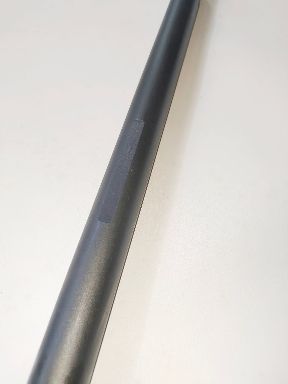 Black coated wireline flow tube with a machined flat detail.