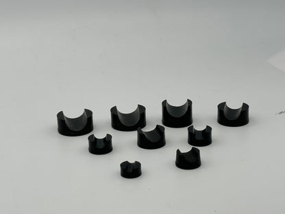 Black molded rubber support blocks with round bases and semicircular cradles