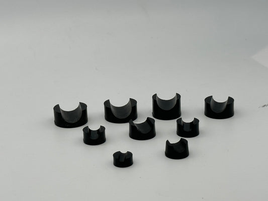 Black molded rubber support blocks with round bases and semicircular cradles