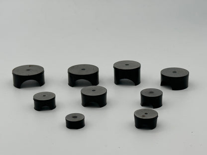 Molded rubber mounting rest pad with central hole and underside clearance arch