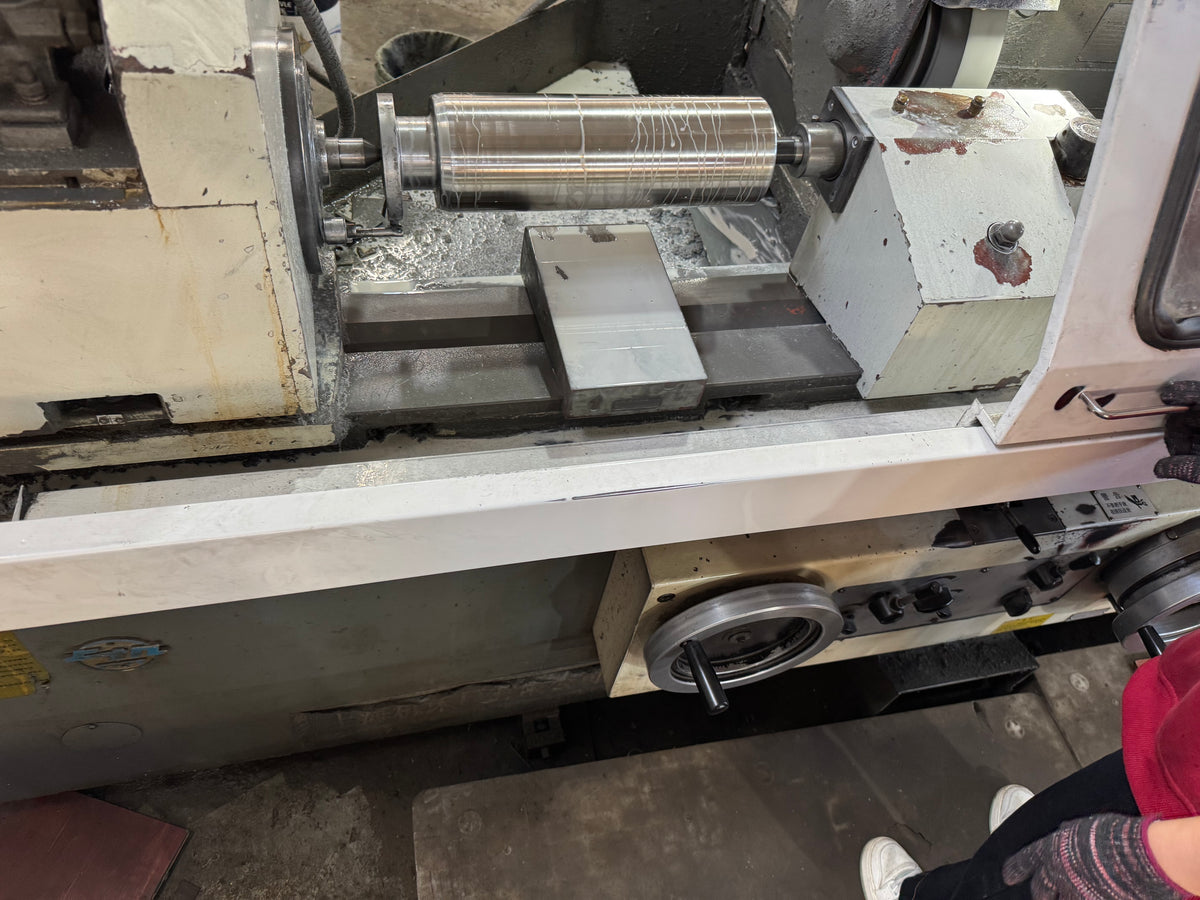 Frac pump plunger body mounted on a lathe during machining