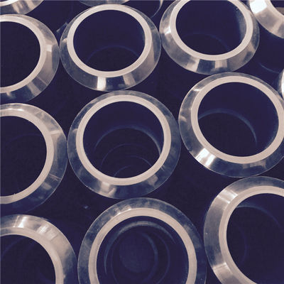 Batch of circular black molded rubber components with metallic outer surfaces