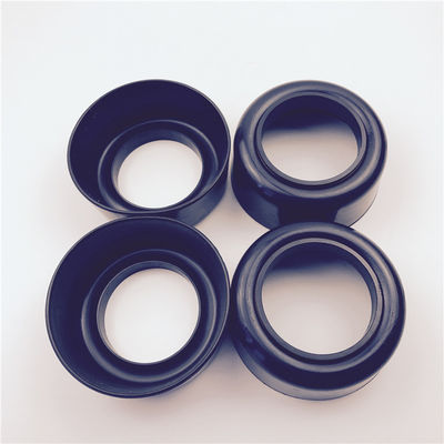 Set of four black cup-shaped molded rubber components with central bores
