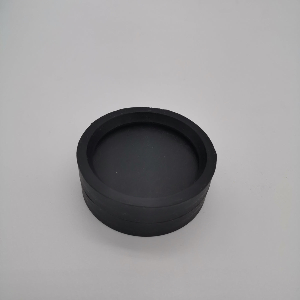 Cup-shaped molded rubber end cap with a recessed closed face