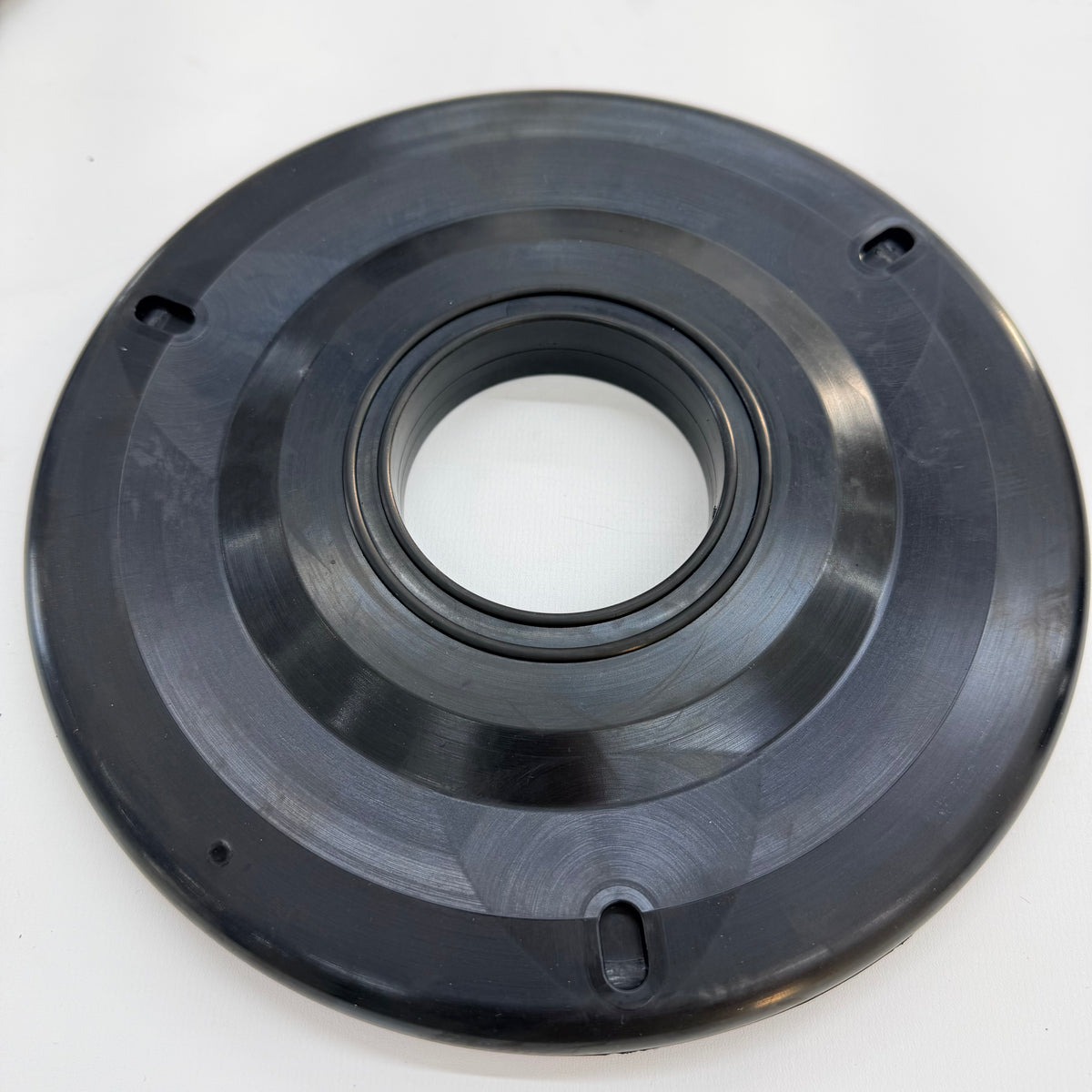 Black circular drill pipe wiper with a central opening and three elongated outer openings