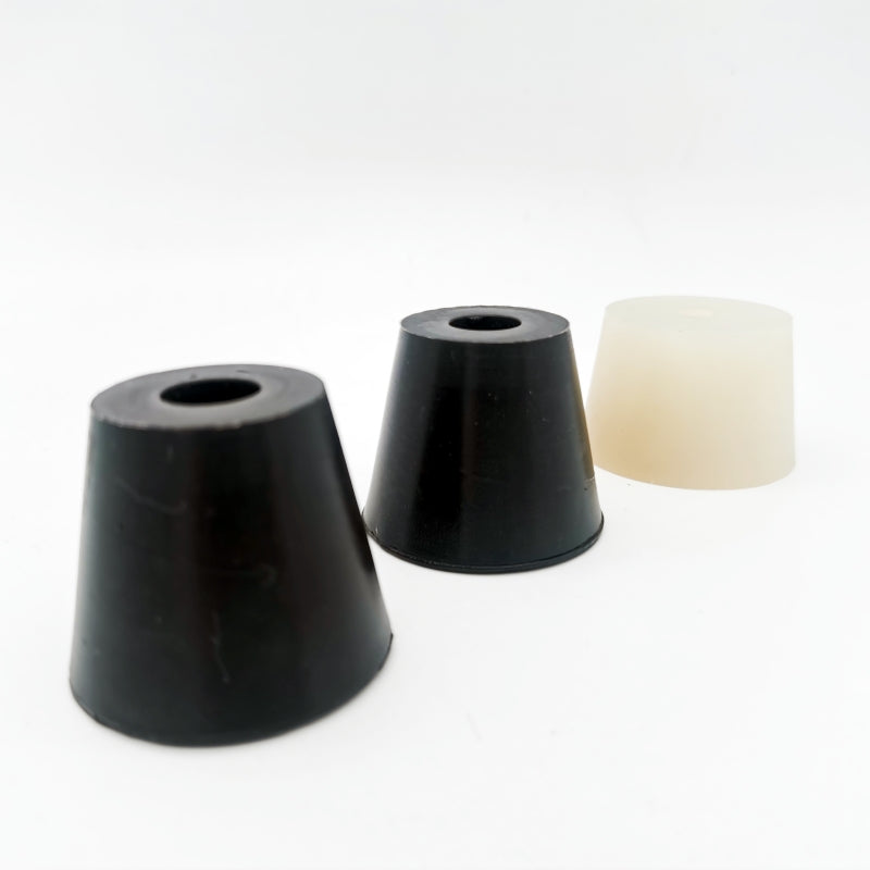 Two black tapered components with central openings beside a light-colored tapered component