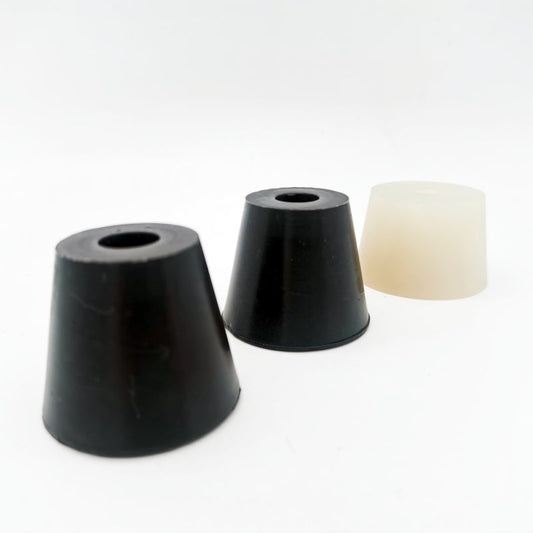 Two black tapered components with central openings beside a light-colored tapered component