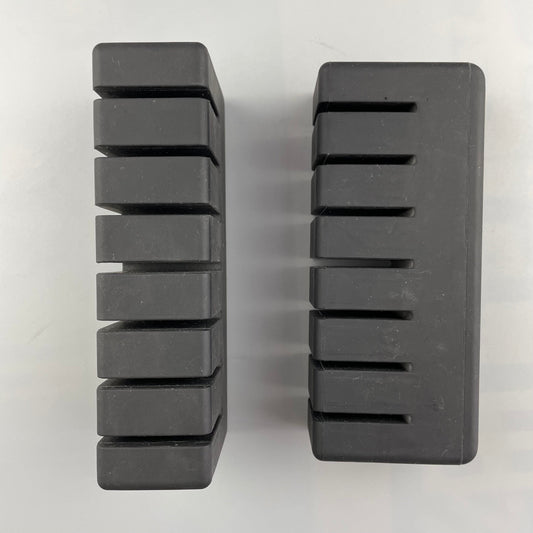 Two rectangular black molded blocks with parallel slots
