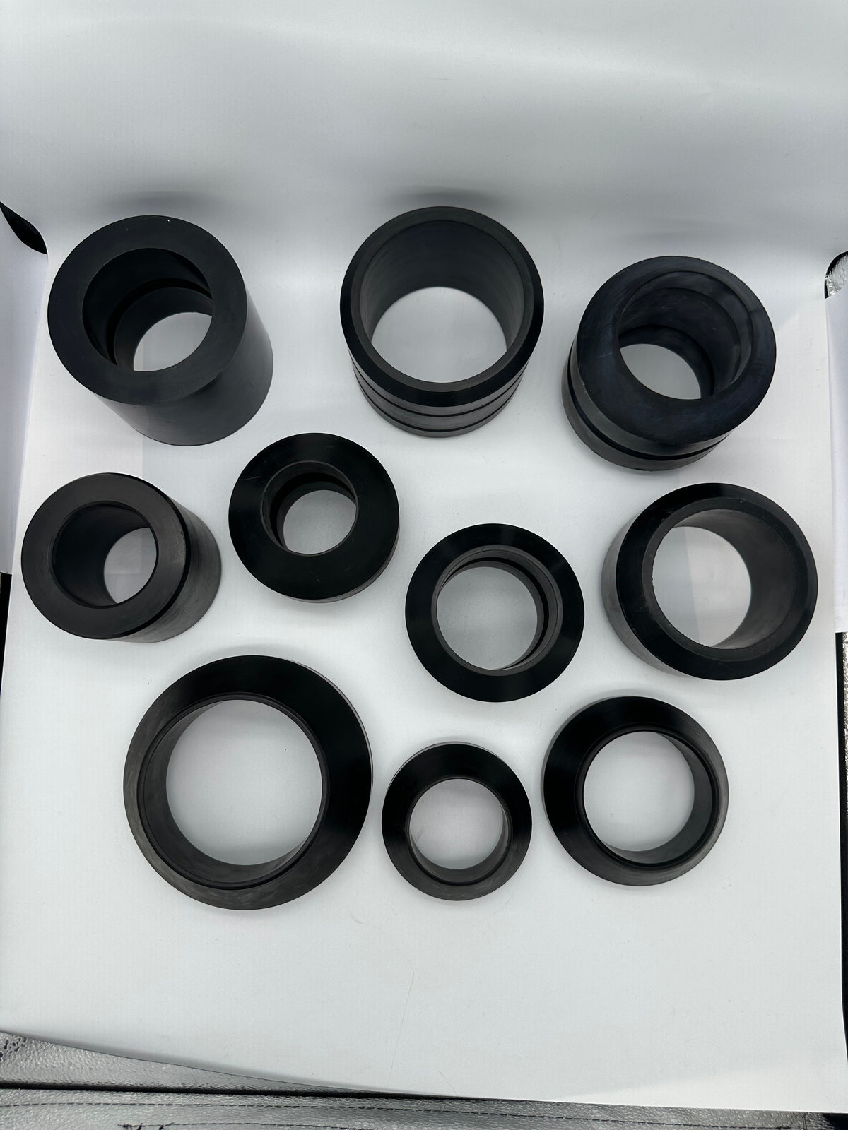 Top detail of molded rubber sleeve profiles with varied bores and outer contours
