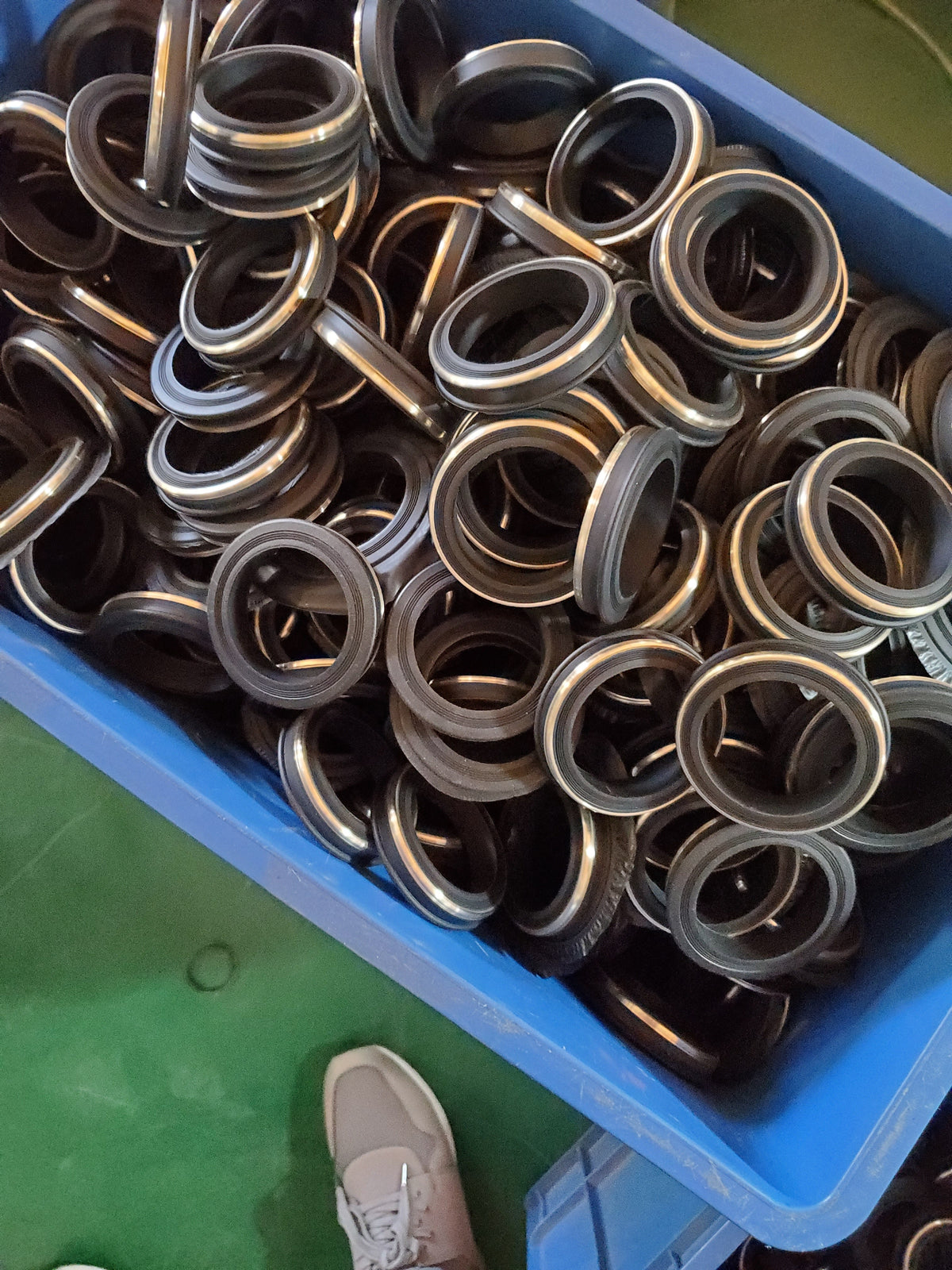 Metal-reinforced rubber seal rings shown in bulk.