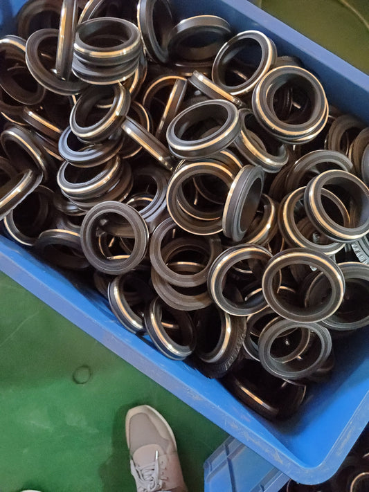 Metal-reinforced rubber seal rings shown in bulk.