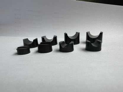 Side detail of black rubber pipe-saddle blocks showing cradle and base profiles