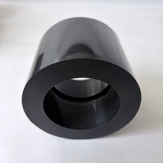 Close-up end view of a black cylindrical molded rubber component with an open center bore