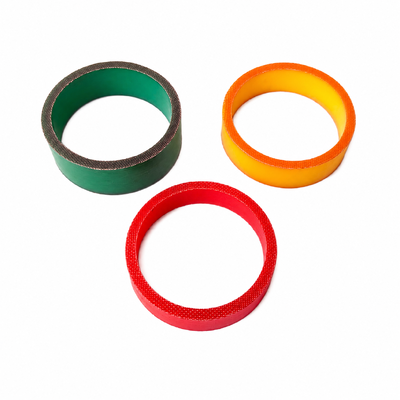 Green, orange and red fabric-faced molded rubber cylinders with center bores