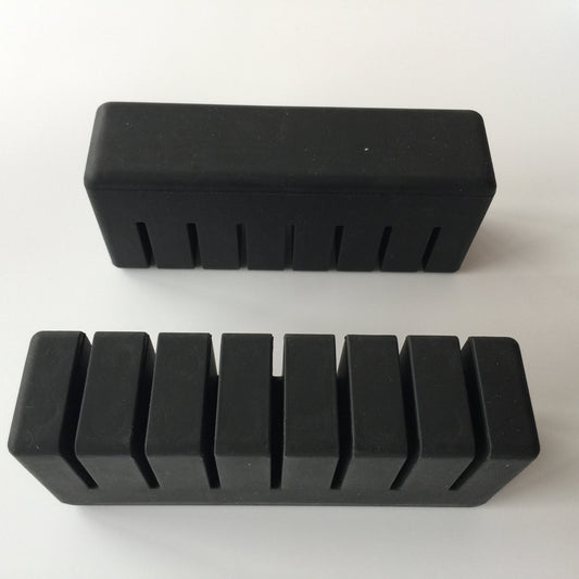 Grooved rectangular molded rubber pad shown from two sides