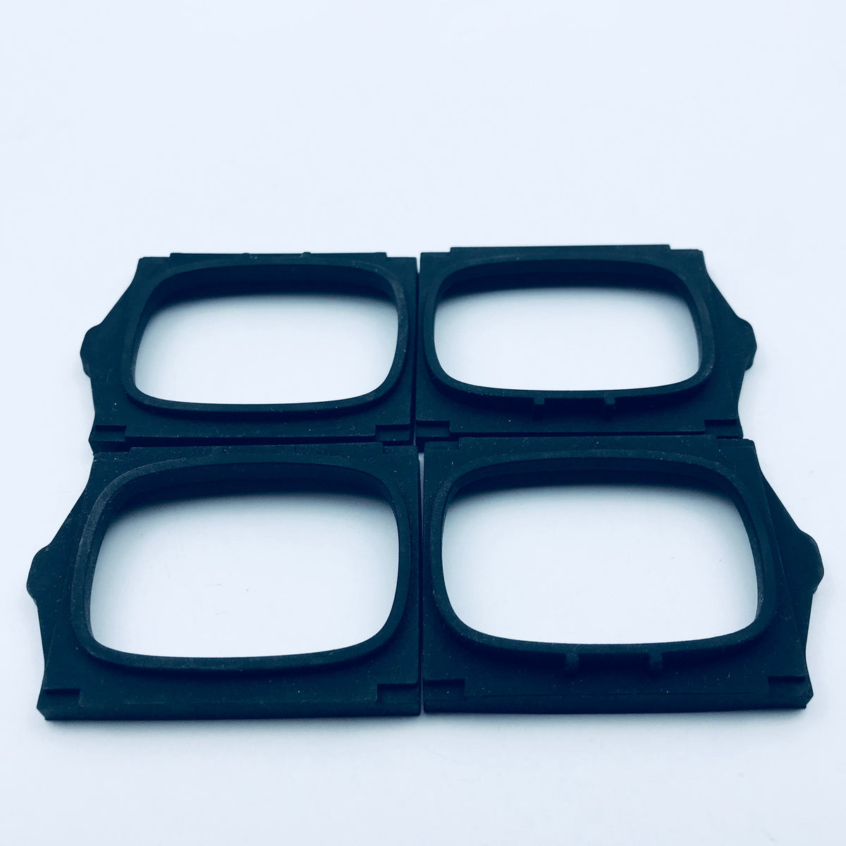 Molded rectangular rubber frame seals with rounded openings and locating features