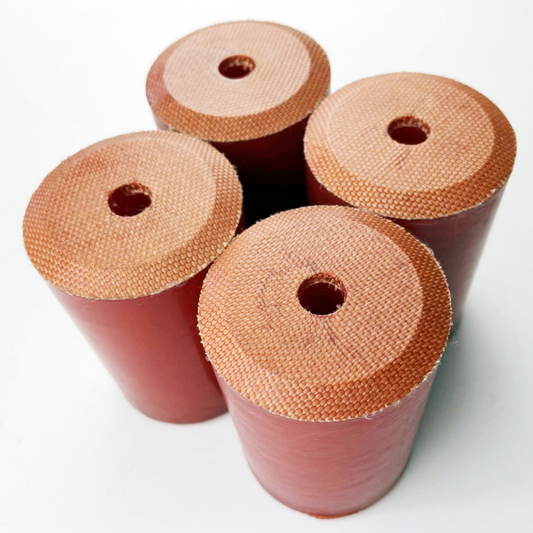 Red molded cylindrical components with visible fabric reinforcement on the end faces