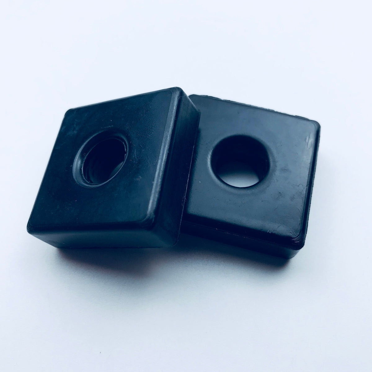 Square molded rubber mounting blocks with central through holes
