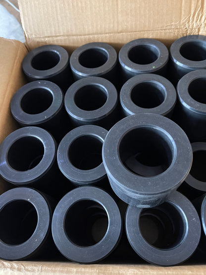 Thick-wall molded rubber bushings with center bores in a production batch