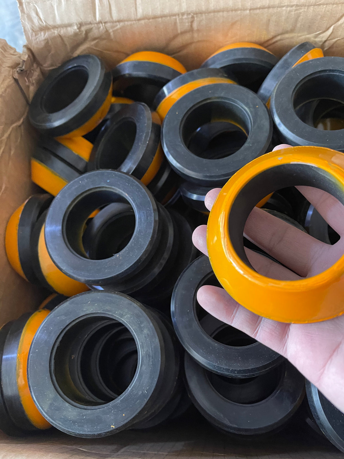 Black and orange thick-wall molded components with center bores